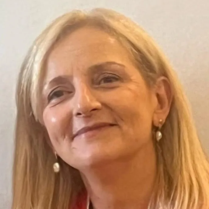 Retrato de la Dra. Myrian E. Sanjurjo, de pelo rubio a la altura de los hombros, sonriendo.